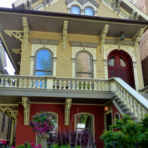 “Close-up photograph of a two-story house with a garden in front.”